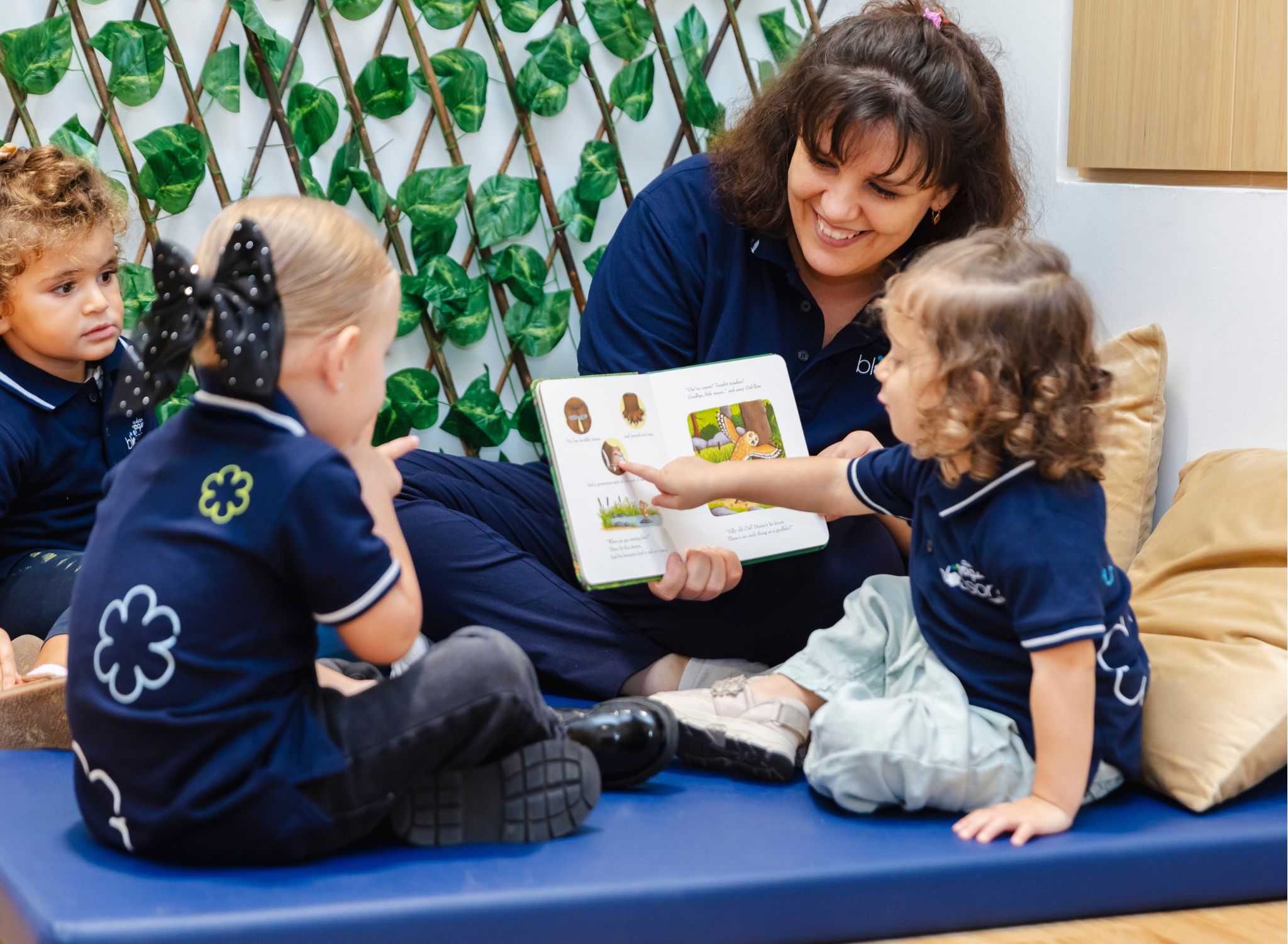 teacher holding a book for children to learn