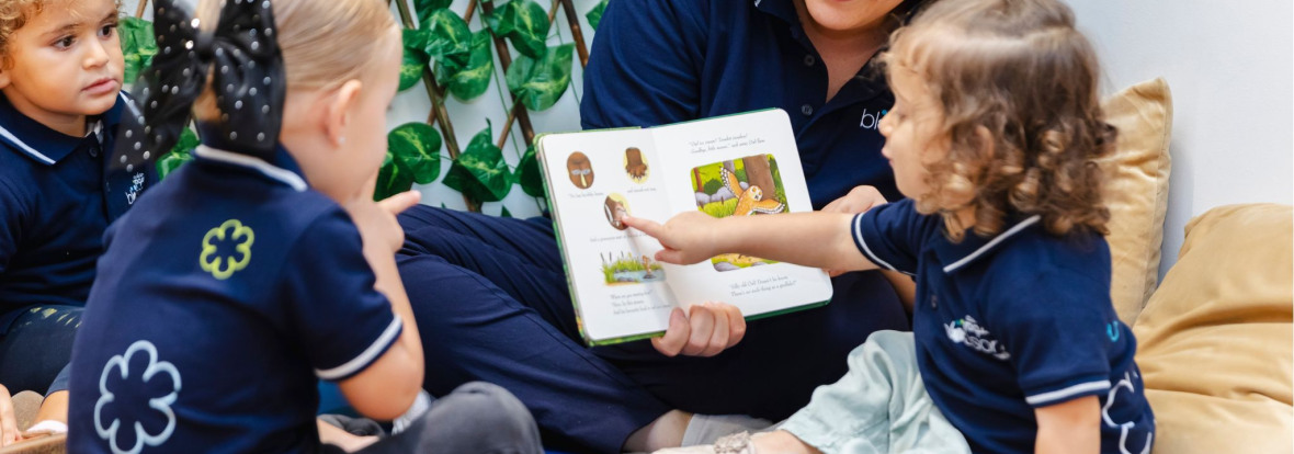 teacher holding a book for children to learn